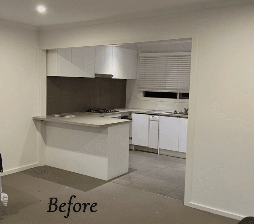 Beaumaris unit kitchen before renovation — dated white cabinets and dark splashback