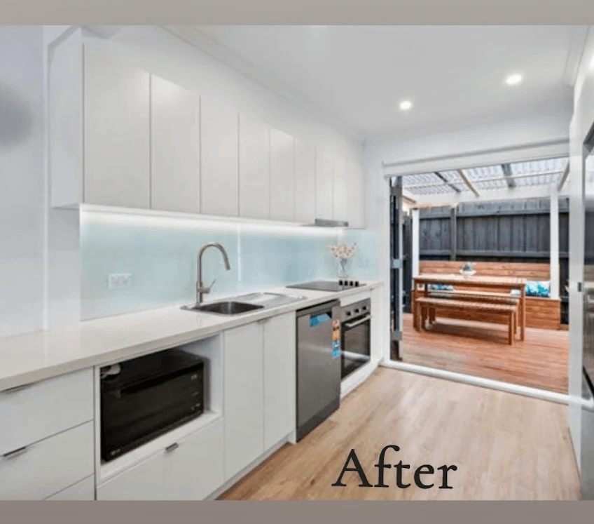 Beaumaris unit kitchen after renovation — bright modern kitchen with glass splashback opening onto a deck