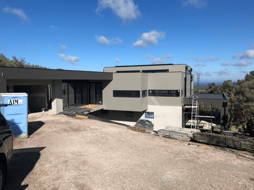 Near-finished modern home under a blue sky